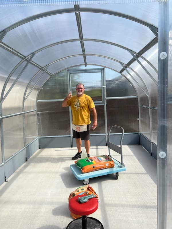 Customer gardening in their greenhouse